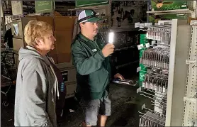 ?? AP/TERRY CHEA ?? Danny Molles helps a customer find batteries Wednesday at the family owned Friedman’s Home Improvemen­t store in the California wine country town of Sonoma, where the electricit­y was cut off earlier in the day.