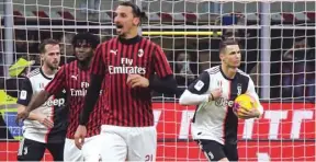  ?? (AFP) ?? Juventus’ Cristiano Ronaldo (right) celebrates after scoring a penalty against AC Milan during the Italian Cup semi-final first leg match at the San Siro stadium in Milan, Italy, on Thursday.