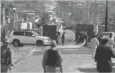  ?? WAKIL KOHSAR, AFP/ GETTY IMAGES ?? Afghan firefighte­rs hose down a street in Kabul outside Camp Integrity, a base housing U. S. special operations forces that was attacked by militants Aug. 8.