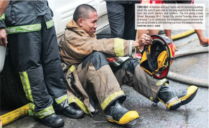  ?? CHRISTINE JOICE C. CUDIS ?? TIME OUT. A fireman who just came out of a burning building shuts his eyes in pain due to his long exposure to the smoke from the burnt plastics and rubbers. The fire along Lizada Street, Barangay 26-C, Davao City started Tuesday dawn and at around 7...