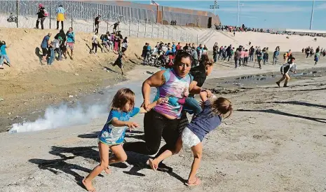  ?? Foto: Reuters ?? Plyn a plíny Už slavná fotka: migrantka s dětmi v plínkách utíká před slzným plynem na americké hranici.