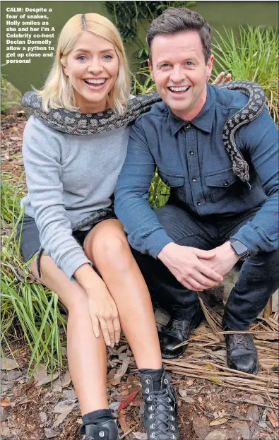  ?? Pictures: REX/Shuttersto­ck ?? CALM: Despite a fear of snakes, Holly smiles as she and her I’m A Celebrity co-host Declan Donnelly allow a python to get up close and personal