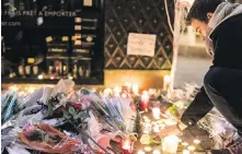  ??  ?? A man lights a candle on Wednesday at a memorial set up at the site of Tuesday’s Christmas market attack that left two dead and wounded at least 13, in Strasbourg, eastern France.