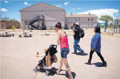  ?? MARLA BROSE/JOURNAL ?? Melissa Theis wheels her 2-year-old son Julian across a yard at Joy Junction. Theis and her husband relocated from Florida and said they were grateful to find a shelter that keeps families together.