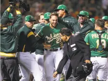  ?? Ben Margot / Associated Press ?? The A’s Matt Olson (28) celebrates after hitting the game-winning home run off the Astros’ Tony Sipp in the 10th.