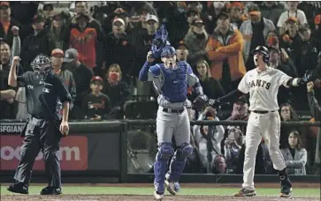  ?? Robert Gauthier Los Angeles Times ?? THREE reactions sum up the final strike of Game 5 between the Dodgers and Giants. Umpire Doug Eddings calls out the Giants’ Wilmer Flores, far right, on strikes, while Dodgers catcher Will Smith celebrates.