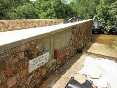  ?? EVAN BRANDT — DIGITAL FIRST MEDIA ?? On Monday, PennDOT reopened the 151-year-old Hare’s Hill Road bridge over French Creek which now sports a new historic plaque to mark the work.