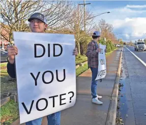  ??  ?? Burke Matthews, left, and Josh Shipley encourage passers-by to make their voices heard Tuesday in front of Astoria High School in Oregon.