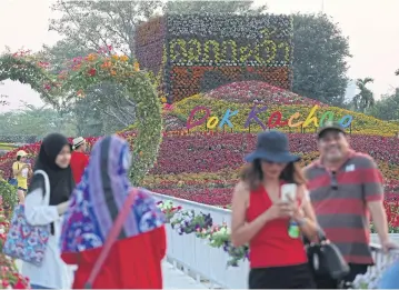  ?? VARUTH HIRUNYATHE­B ?? Tourists take photograph­s at Dok Kachao in Samut Prakan province. The Tourism and Sports Ministry aims to boost domestic market travel with a new stimulus package this week.