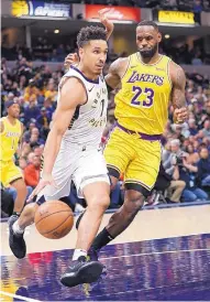  ?? MICHAEL CONROY/ASSOCIATED PRESS ?? Indiana’s Malcolm Brogdon (7) drives past LeBron James during the Pacers’ win over the Lakers Tuesday.