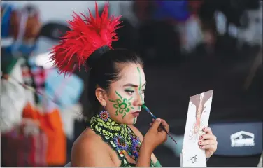  ?? ?? A dancer applies makeup Aug. 13 prior to the anniversar­y ceremony.