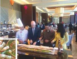  ??  ?? A LARGE Vietnamese baguette sandwich called a banh mi is cut into serving pieces by (above, L-R) chef Tran Kim Hoang Trong, Crimson Filinvest general manager Gerhard Doll, Vietnam Ambassador Ly Quoc Tuan, and performer Dong Nghi during the press launch...