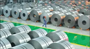  ?? MU YU / XINHUA ?? A worker patrols the steel coil repository at HBIS Group’s Hansteel Co.