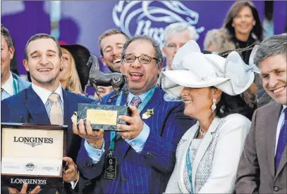  ?? Brynn Anderson The Associated Press file ?? Ahmed Zayat, center, celebrates in the winners’ circle after American Pharoah won the Breeders’ Cup Classic in 2015. Zayat, who owns American Pharoah, has filed for bankruptcy and that could cause problems in the racing industry.