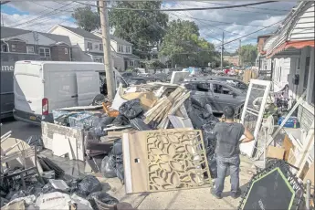  ?? BENJAMIN NORMAN — THE NEW YORK TIMES ?? Debris is removed from homes flooded by the remnants of Hurricane Ida in New York on Sept. 3. As extreme weather becomes more common, insurance companies are rethinking which homes to cover and at what price.