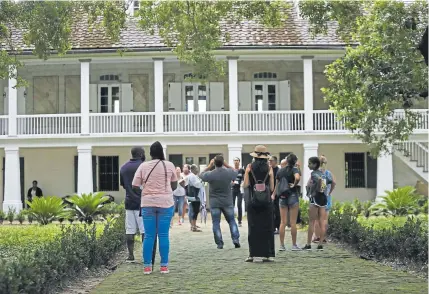  ?? Press file Gerald Herbert, Associated ?? Visitors walk outside the main plantation house at the Whitney Plantation in Edgard, La., in 2017. The Whitney documents slavery at a pre-Civil War plantation near New Orleans but doesn’t mention the slaves who toiled there.