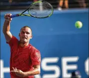  ?? RICK LOOMIS / THE NEW YORK TIMES ?? Mikhail Youzhny of Russia returns a volley to Marcos Baghdatis of Cyprus during their U.S. Open match in New York last week. Youzhny was later forced to withdraw from the match because of severe muscle cramps, and ended his Grand Slam quest.