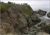  ?? KENT PORTER — THE PRESS DEMOCRAT VIA AP ?? Bodega Bay firefighte­rs work to secure the scene of a crash after a vehicle plummeted from the Bodega Head parking lot in Bodega Bay through a wood barrier, left, landing upside down 100 feet to the rocky shoreline, killing two people in the SUV, Saturday.