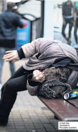  ?? ?? A man lies slumped in Piccadilly Gardens