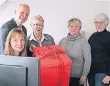  ?? FOTO: SPARKASSE ?? Sparkassen-Vorstand Dirk Abel übergibt das symbolisch­e rote Päckchen an Claire Günzel (2. v. l.) und ihr Team von der Kinderherz­hilfe.