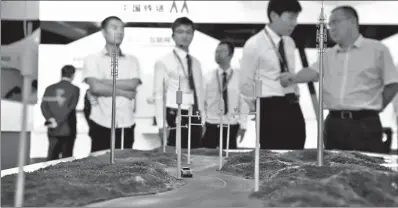  ?? LI XIN / XINHUA ?? Visitors watch a model of Hainan Wanning informatio­nalized expressway at the stand of China Tower at PT Expo China 2016, held in Beijing.