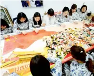  ?? AFP ?? Women work together on an embroidery at a workshop in yangzhou, China. —