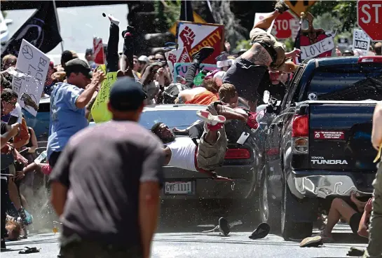  ?? ?? Une voiture fonce sur des personnes qui manifesten­t contre un rassemblem­ent de l’ultradroit­e à Charlottes­ville, le 12 août 2017. (Ryan M. Kelly/The Daily Progress via AP)