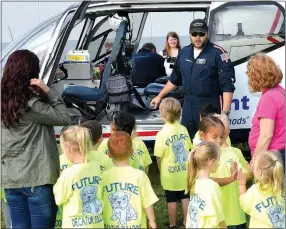  ?? Westside Eagle Observer/MIKE ECKELS ?? Med Flight Air Evac pilot Chris Lott (next to helicopter) explains the flight controls and how a helicopter flies to students during the Northside Elementary Fire Safety Day in the school park lot on Oct. 5.