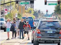  ?? JOE BURBANK/ ORLANDO SENTINEL ?? Edgewater High School students congregate in the middle of traffic on Edgewater Drive, south of Par Avenue in College Park on Tuesday. Orlando again rates worst in pedestrian safety, according to a new ranking.