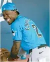  ?? JEFF ROBERSON/AP ?? Marlins’ Jazz Chisholm Jr. laughs with teammates in the dugout before the start of a spring training game against the Astros on March 10 in West Palm Beach.