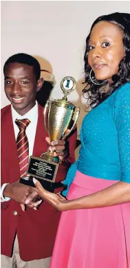  ??  ?? Last year’s first-place winner, Oshel Bryan of Wolmer’s Boys’ School, receives trophy from Rosemary Duncan, manager of Rita Marley Foundation.