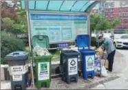  ?? DU LIANYI / CHINA DAILY ?? A community worker sorts trash at a refuse station in a neighborho­od in Beijing’s Xicheng district.