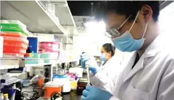  ?? — AFP photos ?? Researcher­s at Peking University’s Beijing Advanced Innovation Center for Genomics conducting tests at their laboratory in Beijing.