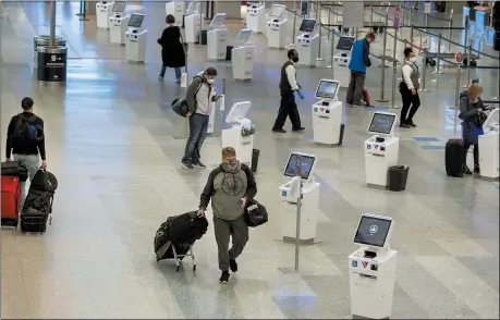  ?? ELIZABETH FLORES — STAR TRIBUNE VIA AP, FILE ?? Travelers make their way through the Minneapoli­s-St. Paul Internatio­nal Airport Nov. 12, during the coronaviru­s pandemic. With the coronaviru­s surging out of control, the nation’s top public health agency advised Americans on Nov. 19, not to travel for Thanksgivi­ng and not to spend the holiday with people from outside their household.