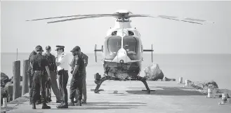  ?? DAX MELMER ?? OPP officers hold a meeting next to a helicopter at the Colchester Harbour marina on Monday.