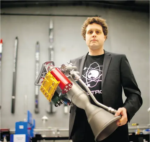  ?? PHIL WALTER / GETTY IMAGES ?? RocketLab chief executive Peter Beck with The Rutherford rocket engine at the company’s headquarte­rs in Auckland, New Zealand. The Rutherford, a battery-powered rocket engine printed on 3D parts developed RocketLab, is set to reduce the cost for...