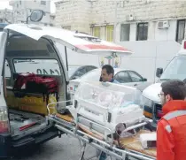  ?? — AFP ?? Lebanese Red Cross members wheel a baby in an neonatal intensive care unit (NICU) into an ambulance during clashes in Ain al Hilweh camp near the southern coastal city of Sidon on Saturday.