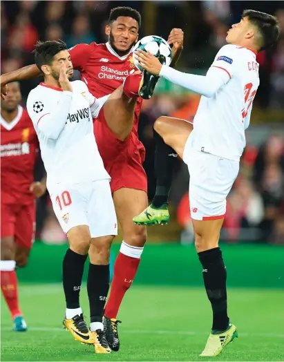  ??  ?? Liverpool’s Joe Gomez attempts to get a leg up on Sevilla’s Ever Banega and Joaquin Correa during last night’s Champions League group clash at Anfield. The game finished 2-2.