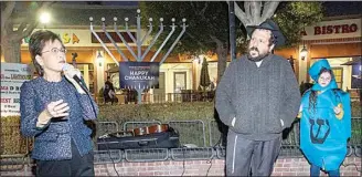  ?? ROD THORNBURG / FOR THE CALIFORNIA­N, FILE ?? Mayor Karen Goh speaks to the crowd, including Rabbi Shmuel Schlanger and Mia Odlia, before lighting the menorah during the first night of Hanukkah at The Marketplac­e last year. The lighting returns on Sunday.