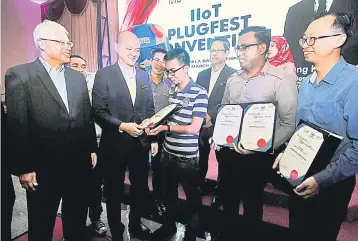  ??  ?? Ong (second left) hands out certificat­es to receipient­s during the Industrial Internet of Things (IIOT) Plugfest Convention 2019 yesterday. Also present are E&amp;E Productivi­ty Nexus chairman Datuk Seri Wong Siew Hai (left) and Malaysian Productivi­ty Corporatio­n Director General Datuk Mohd Razali Hussain. — Bernama photo