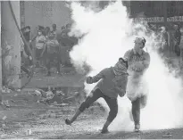  ?? REUTERS ?? A demonstrat­or throws a Molotov cocktail at riot police during ongoing anti-government protests in Baghdad, Iraq on Friday.