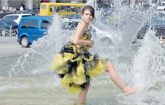  ?? Sergei Supisky/afp/getty Images ?? A woman refreshes herself in a fountain in the centre of Kyiv during a hot day in the Ukrainian capital. Hot water shortages and withheld salaries are starting to bite as the country is struggling to recover from its second recession in four years. The...