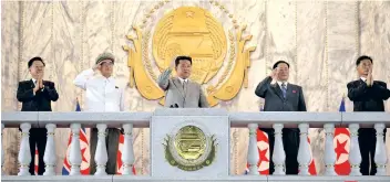  ??  ?? North Korean leader Kim Jong Un, centre, waves from a balcony toward the assembled troops and spectators during the nation’s 73rd anniversar­y at Kim Il Sung Square in Pyongyang
