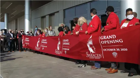  ?? (Pine Bluff Commercial/Dale Ellis) ?? The Pine Bluff Regional Chamber of Commerce “Redcoats” prepare, with the assistance of Mayor Shirley Washington, to cut the ribbon for the official grand opening of the Saracen Casino Resort.