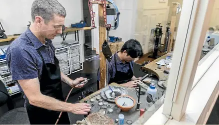  ?? PHOTOS: DAVID UNWIN/STUFF ?? Cameron Jewellery owner Sam Drummond, left, and apprentice James Sheu in the workshop. They had a busy time making 82 rings.