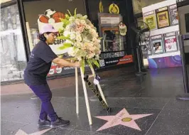  ?? CHRIS PIZZELLO AP ?? A staff member places flowers on Clarence Avant’s star on the Hollywood Walk of Fame on Monday. Avant helped launch or guide careers in a variety of fields.