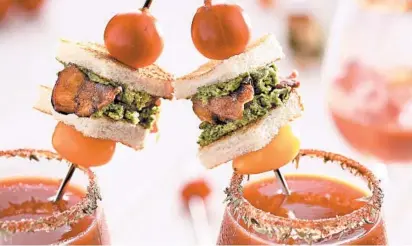  ?? MICHAEL TERCHA/CHICAGO TRIBUNE PHOTOS; MARK GRAHAM/FOOD STYLING ?? Mini BLTs garnish bloody marys with whimsy and an explosion of flavor. A freshly made arugula pesto stands in for the lettuce.