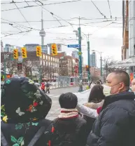  ?? FRANK GUNN / THE CANADIAN PRESS FILES ?? Pedestrian­s wear protective masks in Toronto,
which was one of the first places in Canada to experience SARS-related emergencie­s in 2003.