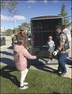  ?? ALLISON GATLIN/VALLEY PRESS ?? Joshua Saylor (left) and his two children, Jaymeson, 6, and Jocelyn (in pink coat), 9, join Ralph Velador in carrying one of the panels of the AV Wall from the trailer, Wednesday morning.