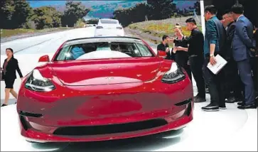  ?? Roman Pilipey EPA/Shuttersto­ck ?? A TESLA Model 3 is displayed last year in Beijing. A trade war flare-up could drive up its price in China.